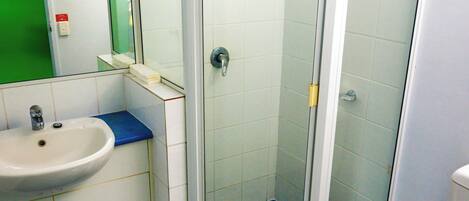 Un baño con ducha, lavabo e inodoro.