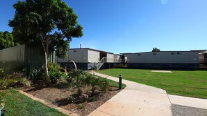 A building with a grassy courtyard, a tree, and a pathway. - Leichhardt Accommodation (Mornington)