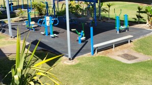 An outdoor gym area with exercise equipment and a shaded seating area. - Leichhardt Accommodation (Mornington)
