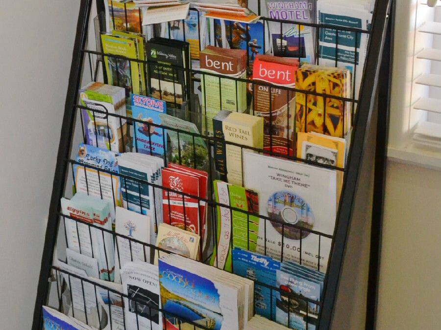 A promotional display rack with various travel brochures and maps, including a visible 'Manning Valley' sign.