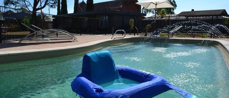 Alberca al aire libre y camastros