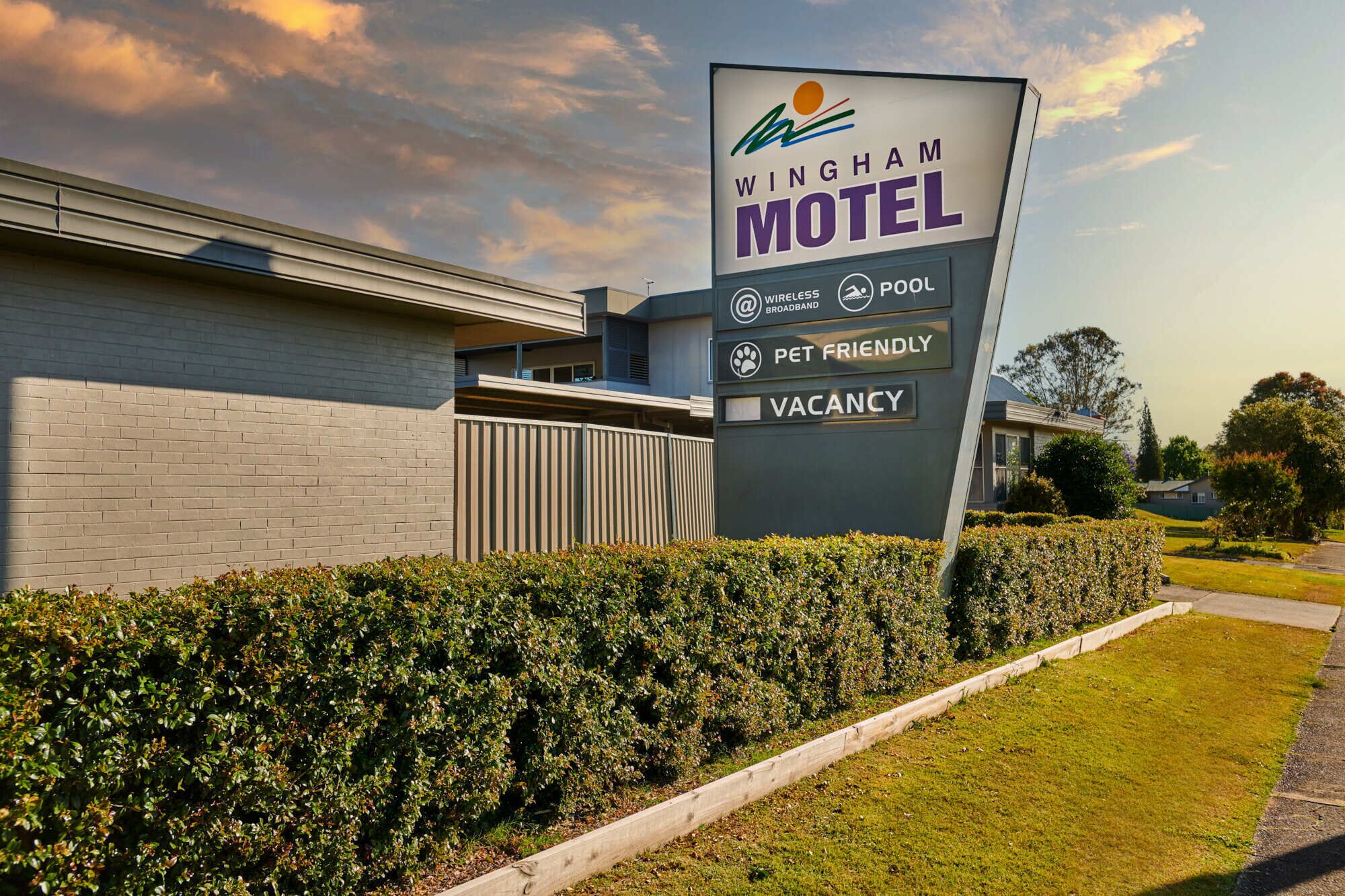 A Wingham Motel sign with amenities including wireless broadband, pool, pet-friendly, and vacancy status.