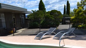 Una piscina nítida amb gandules i una tanca.