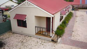 A small, single-story building with a red roof and a porch. - Port Vincent Motel & Apartments (Port Vincent)