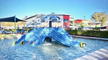 Relax by the pool with a dolphin-themed play area and lounge chairs.