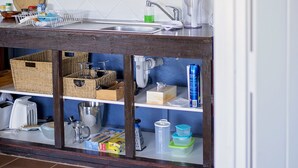 A kitchen with a window, white cabinets, and a wooden countertop. - Karribank (Porongurup)