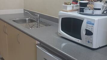 A kitchen with a built-in dishwasher, a microwave, and a sink.