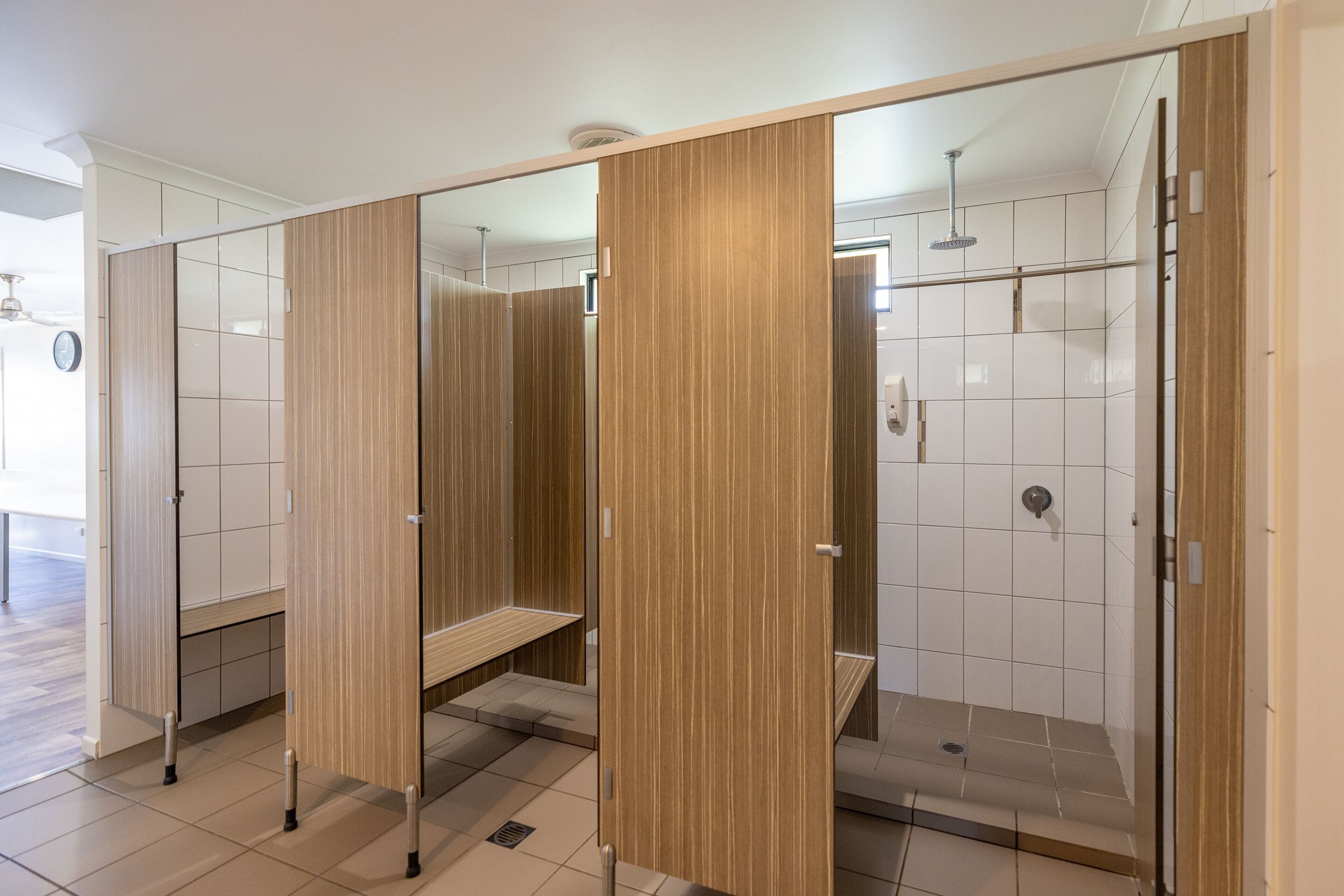 Ein modernes Badezimmer mit drei Holzwänden, einer Duschkabine und einem sichtbaren WC.