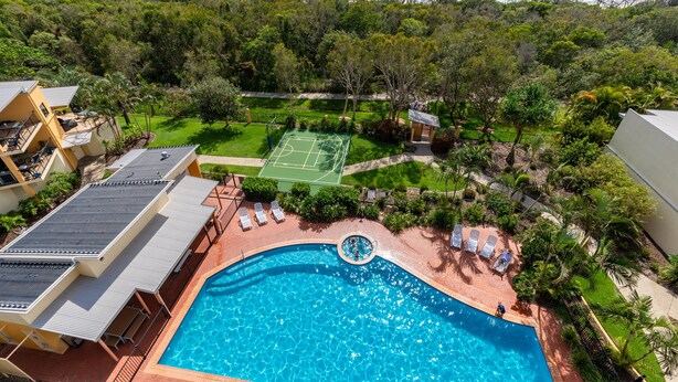 A swimming pool with a tennis court and lush greenery, overlooking the ocean. - Marcoola Beach Resort (Marcoola)