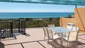 A balcony with a table and chairs, overlooking the ocean. - Marcoola Beach Resort (Marcoola)