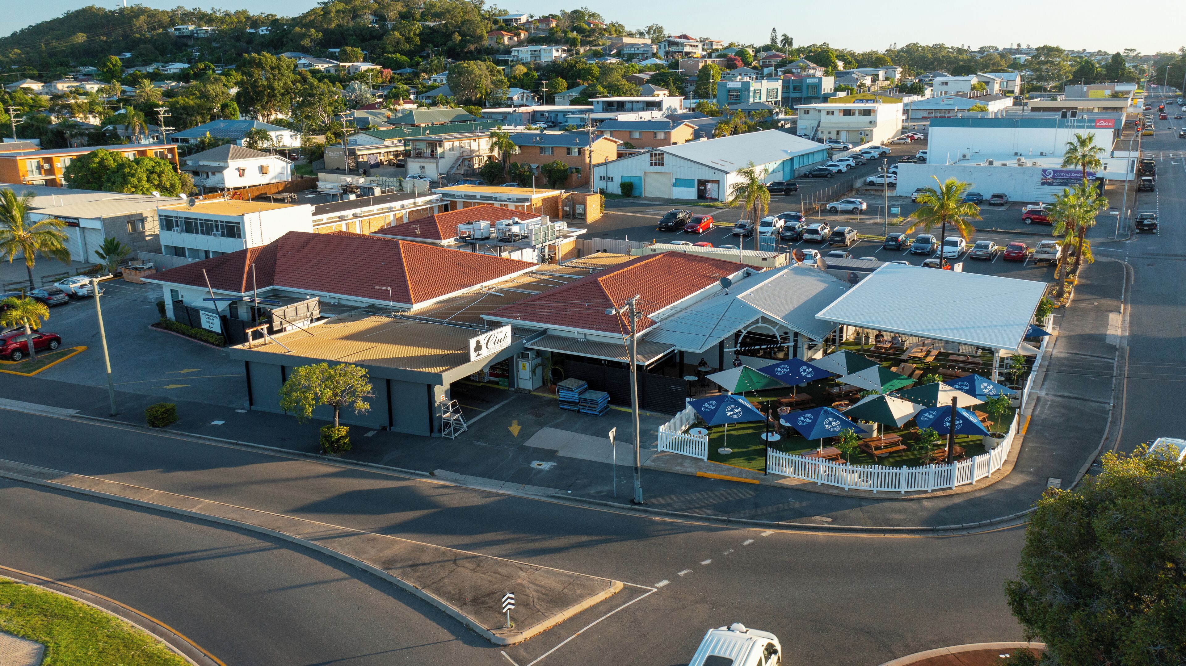 A commercial area with a gas station, a restaurant with outdoor seating, and various shops.