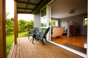 Un espace extérieur abrité, doté d’une terrasse en bois, d’une table et de chaises.
