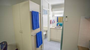 A bathroom with a toilet, sink, and cabinets.