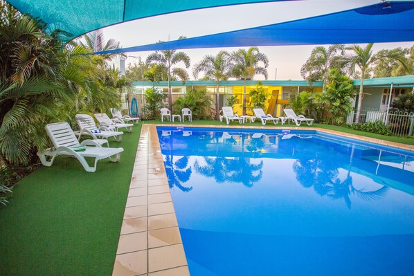 Una piscina al aire libre, tumbonas