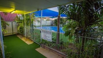 Una piscina al aire libre, sillones reclinables de piscina