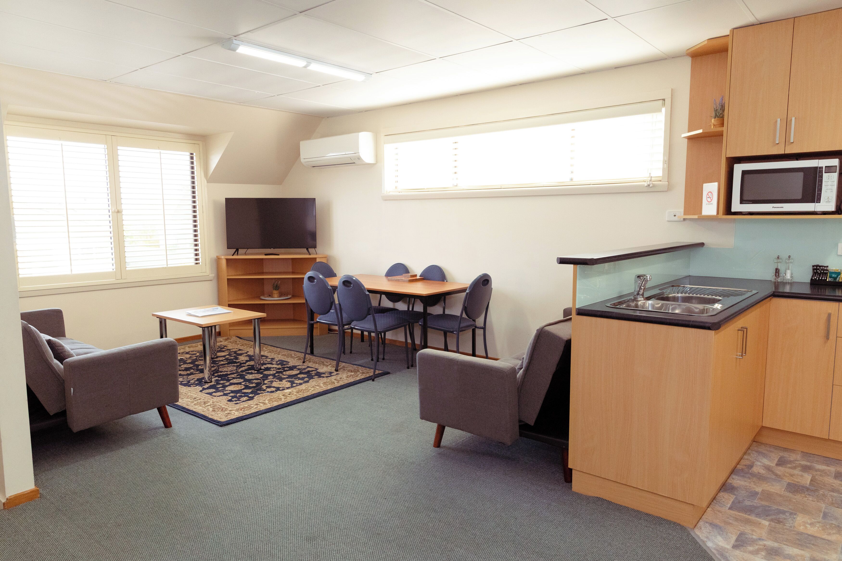 A compact living space with a dining area, kitchenette, and seating.