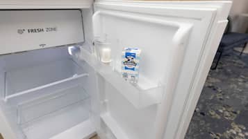 An open refrigerator with a 'FRESH ZONE' label, a carton of Devondale milk, and two glasses on the door shelf.