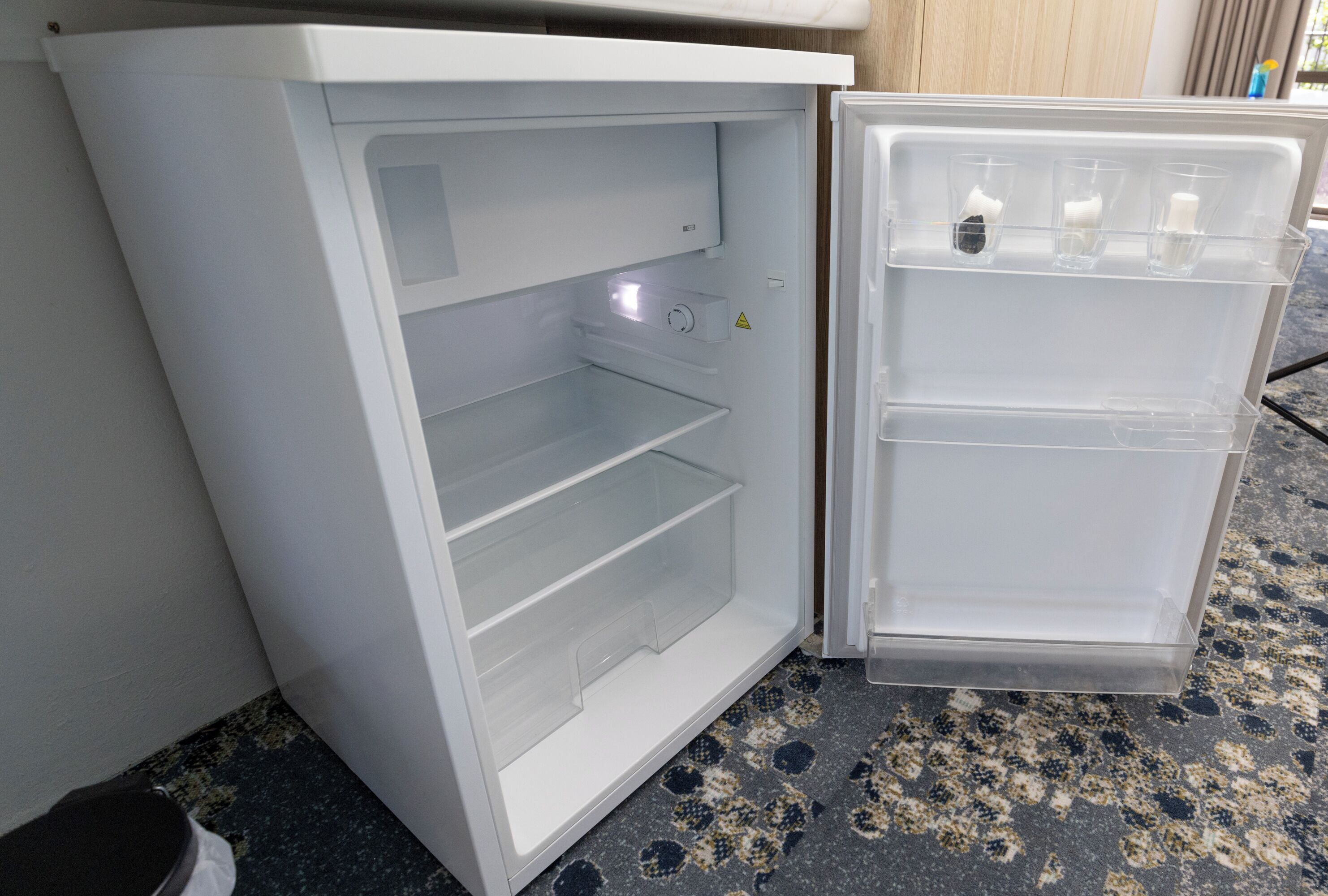 Un refrigerador blanco con compartimento congelador y una repisa.