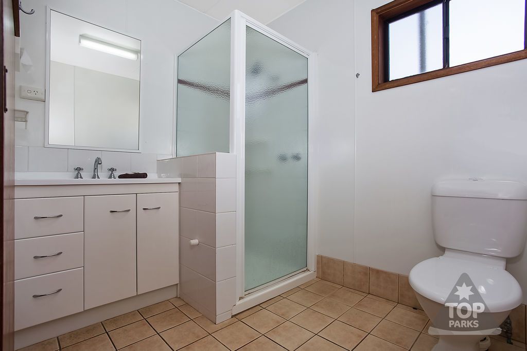 A bathroom with a white sink, mirror, and toilet.