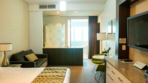 A hotel room with a bed, a desk, a chair, a TV, and a view of the outside. - Walkers Arms Hotel (Walkerville)