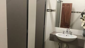 A bathroom with a white sink, a mirror, and a wooden door.