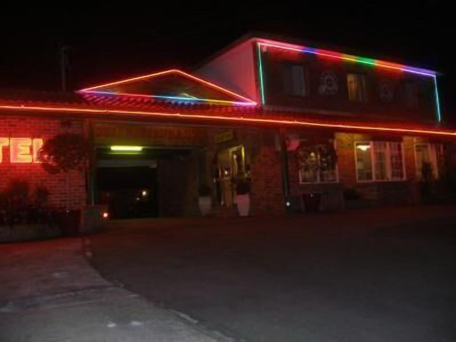 A building with a neon sign and a brick facade.