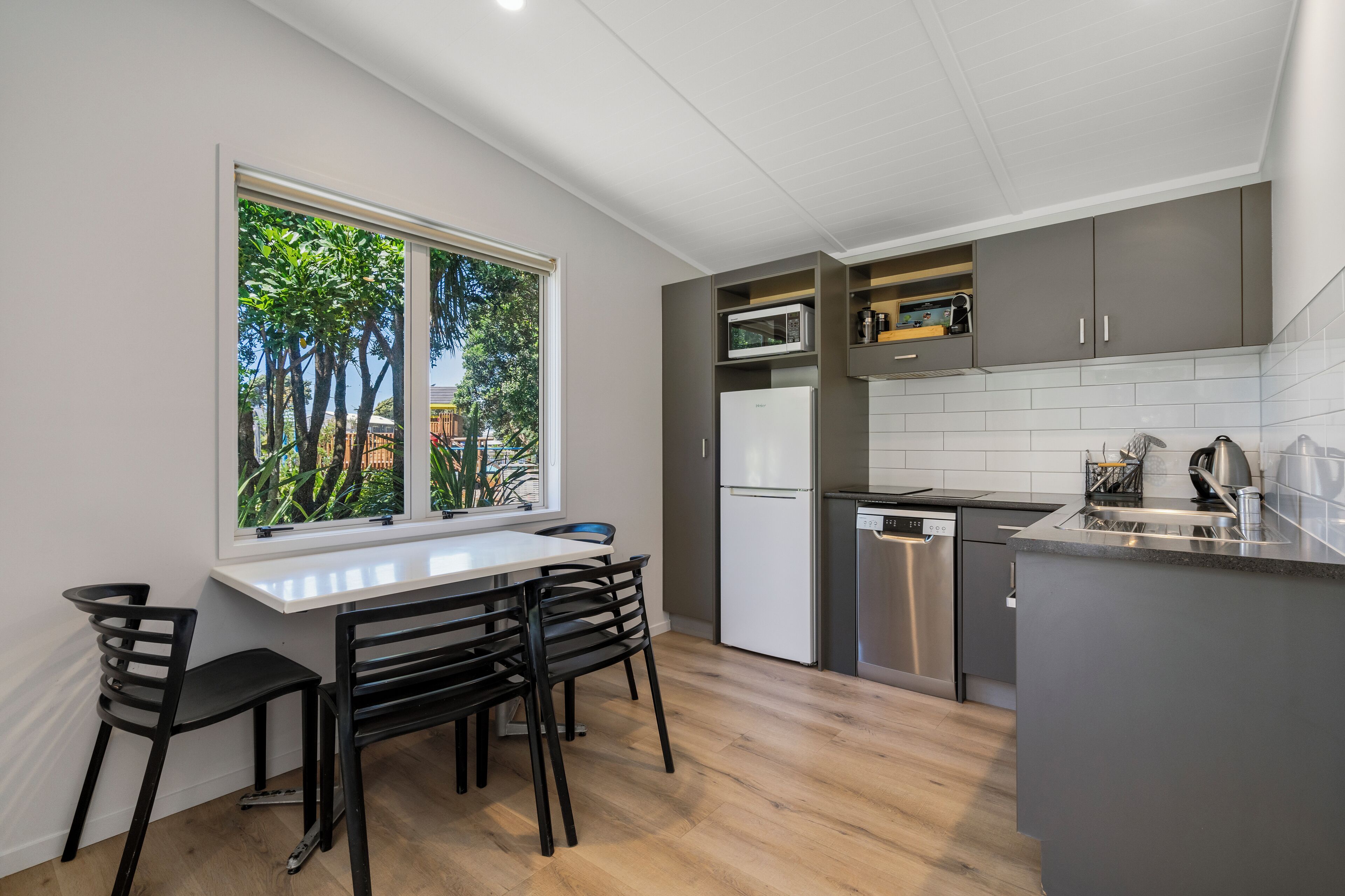 Una cocina moderna con comedor, ventanas amplias y electrodomésticos integrados.