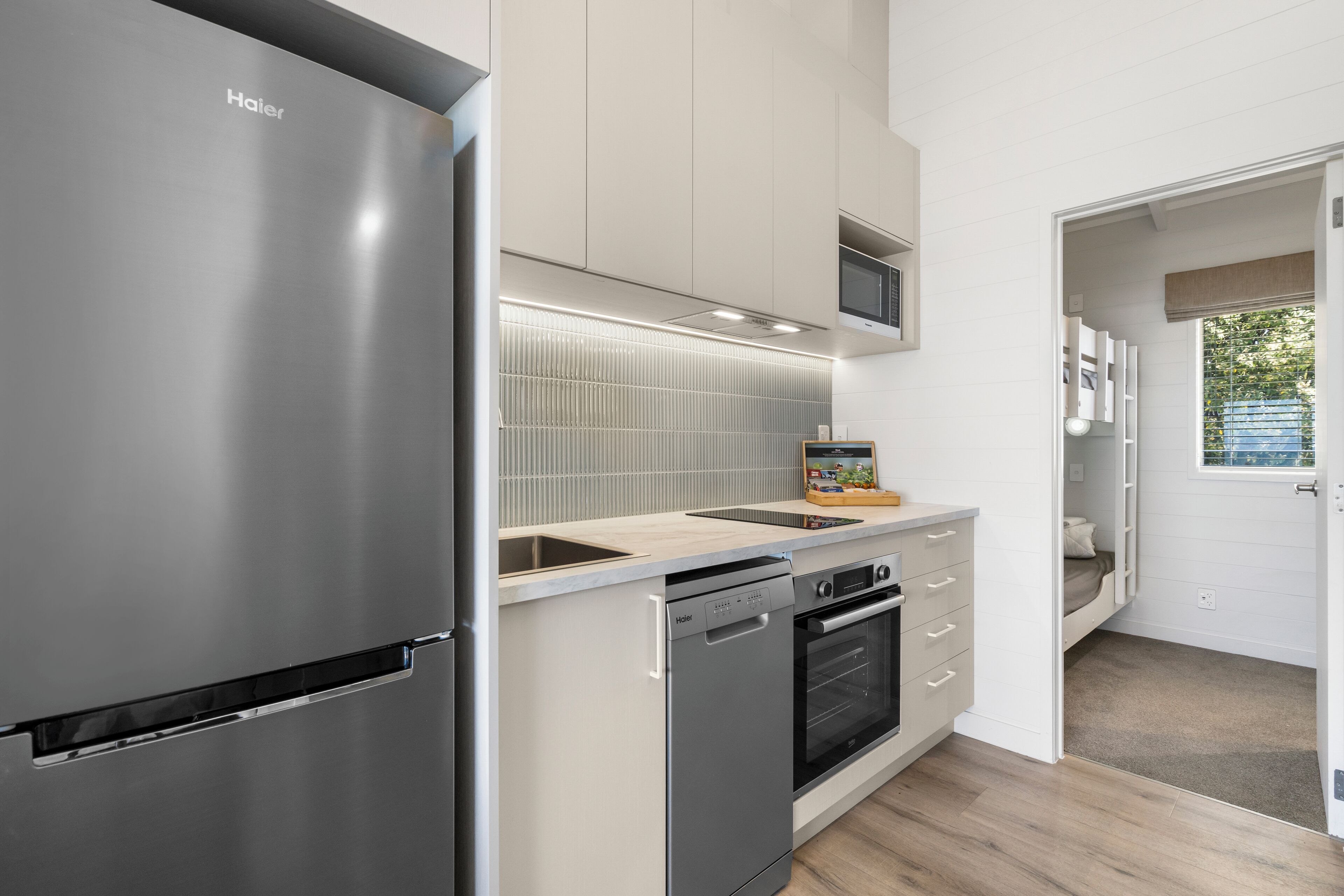 A modern kitchen with a stainless steel refrigerator, a dishwasher, an oven, and a microwave.