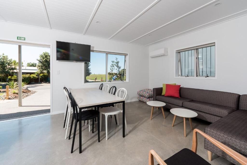 A modern interior with a dining area, sofa, and TV.