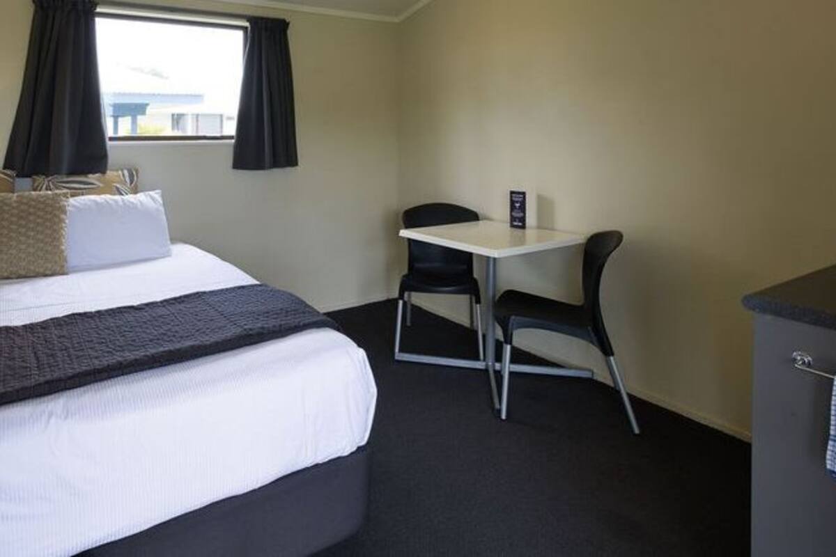Ein Hotelzimmer mit Bett, Schreibtisch und Stuhl.