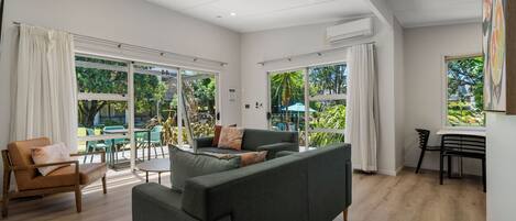 Una sala de estar moderna con un sofá, sillas y un comedor.