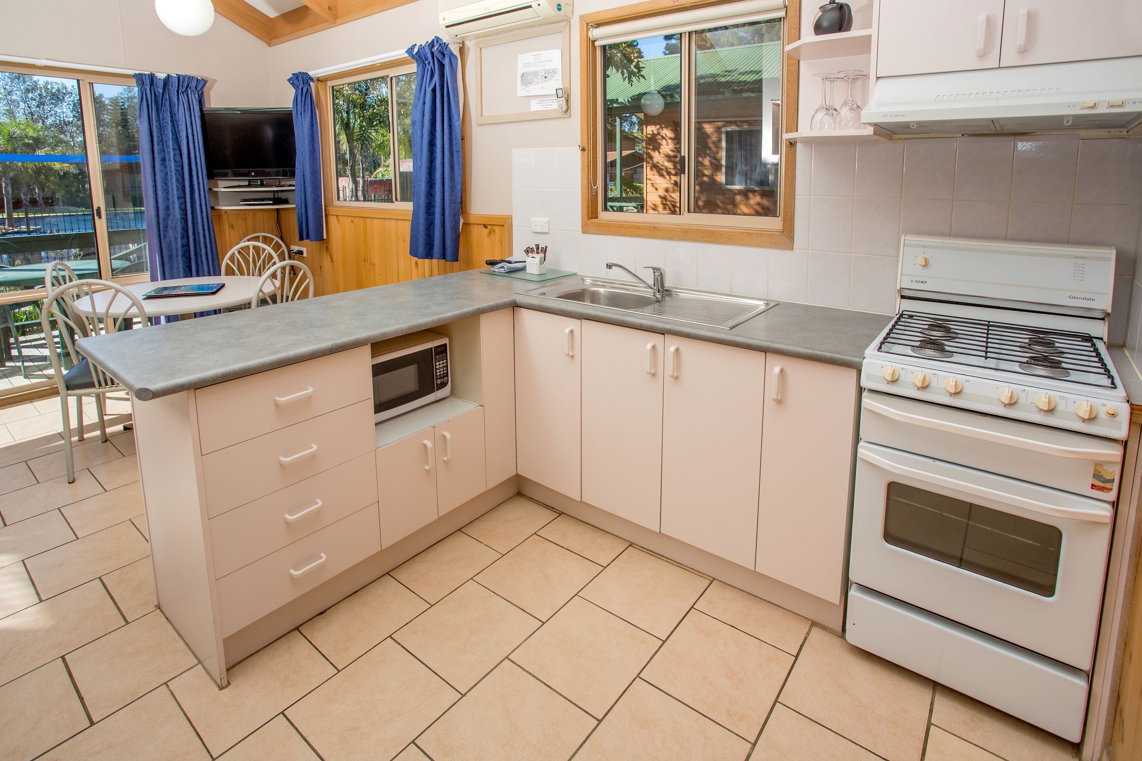 Cocina compacta con horno integrado, microondas y pileta. Cuenta con un comedor con mesa y sillas.