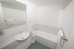 Een aparte badkuip en douche, handdoeken