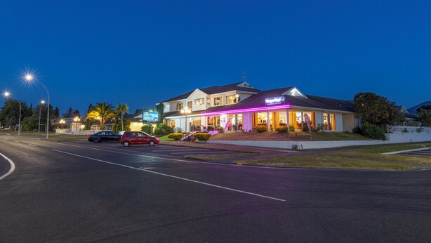 A two-story hotel with a 'Prince' sign, a restaurant named 'Thai Restaurant & Bar' with neon signage, and a parking lot with several cars. - ASURE Prince Motor Lodge (Taupo)