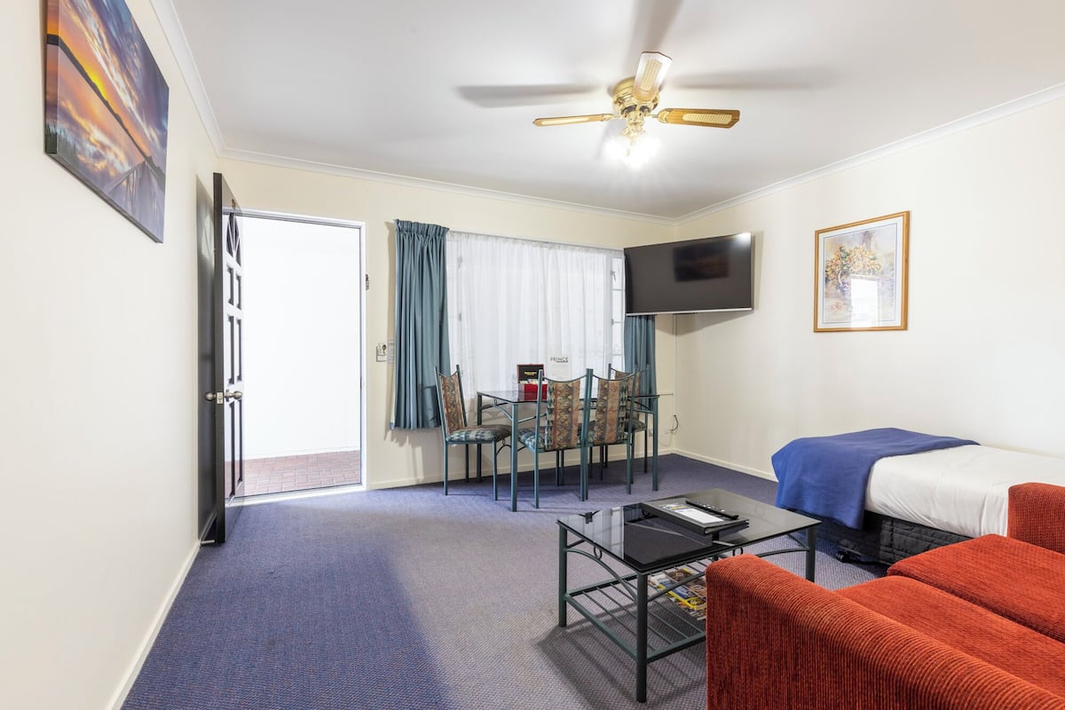 Une chambre d’hôtel avec un lit, une télévision, un bureau et une chaise.