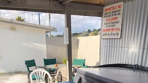 Un bain à remous avec un panneau indiquant qu’il est interdit aux enfants et que la durée maximale d’utilisation est de 30 minutes.