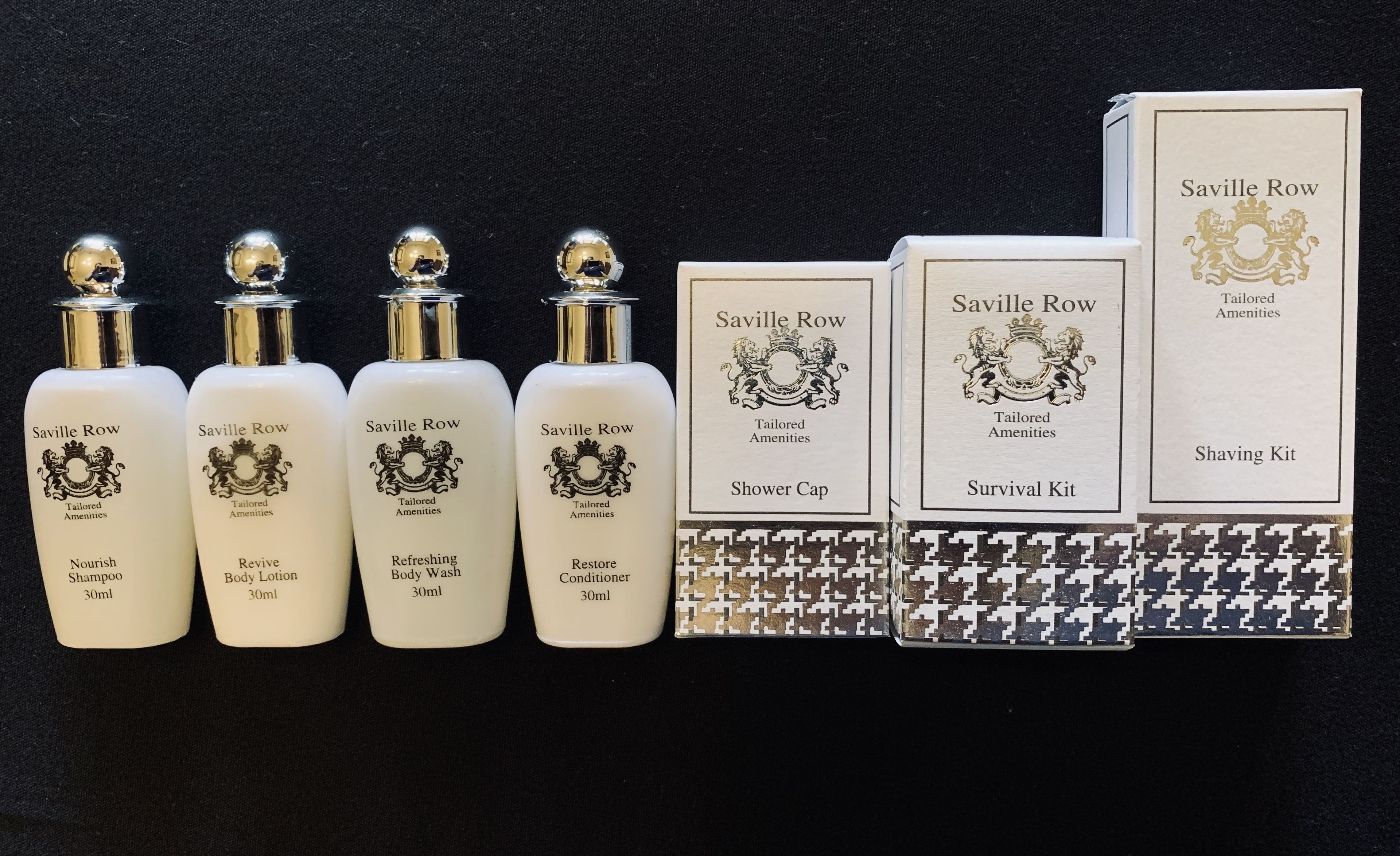 En samling Saville Row toiletartikler, herunder badehue, overlevelsessæt og fire flasker kropsplejeprodukter.