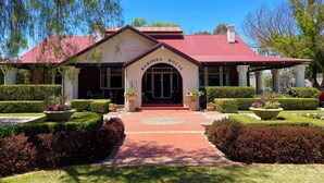 A Barossa House with a red roof, a covered entrance, and well-maintained gardens. - Barossa House (Tanunda)