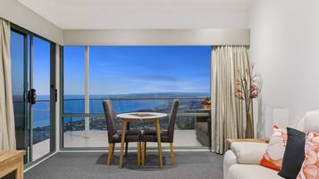 Un salon moderne avec un balcon donnant sur une vue panoramique de la ville.
