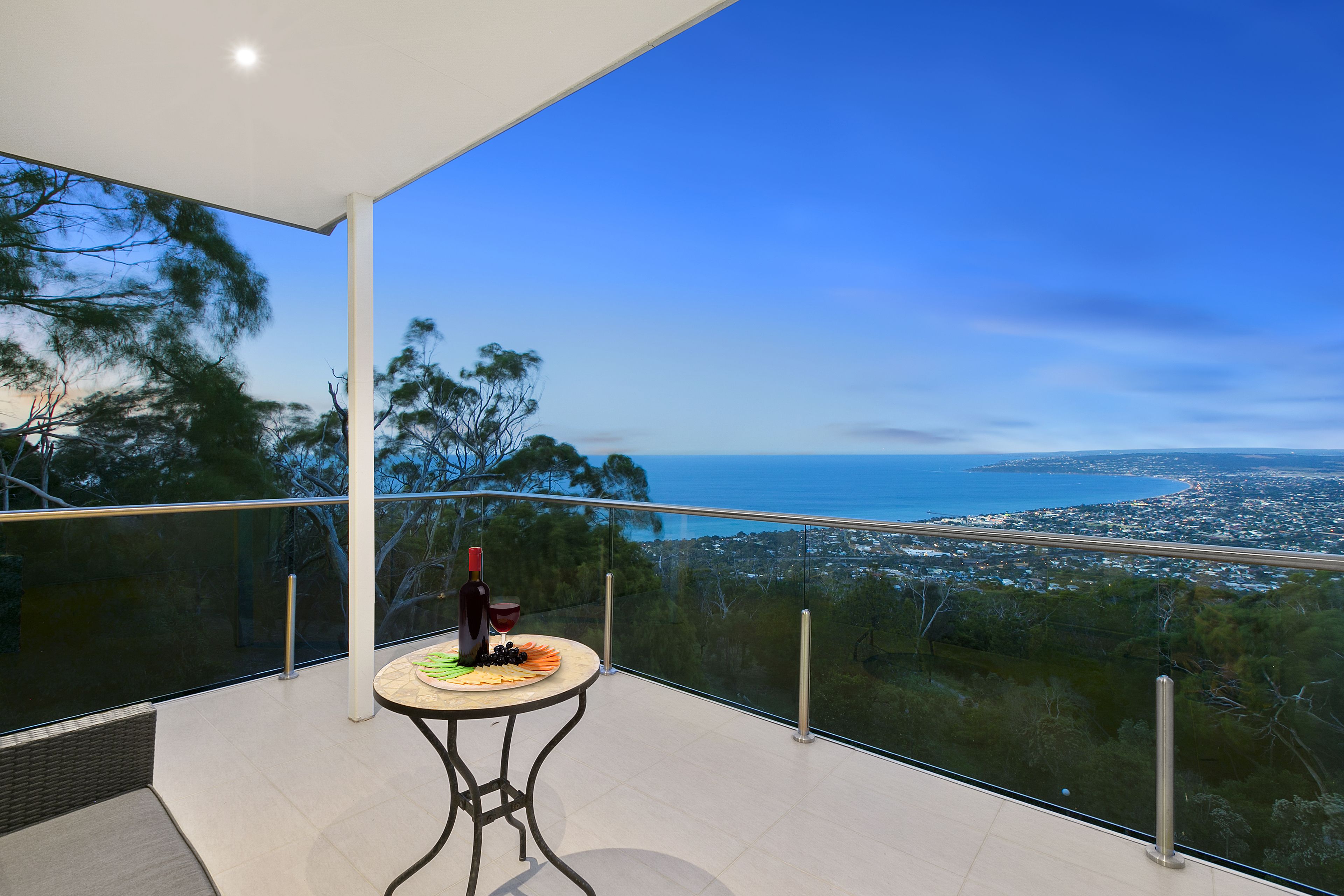 Ein Balkon mit Tisch für zwei Personen, mit Blick auf die Küste.