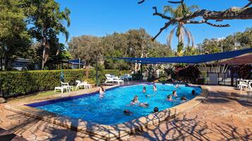 Alberca al aire libre y camastros