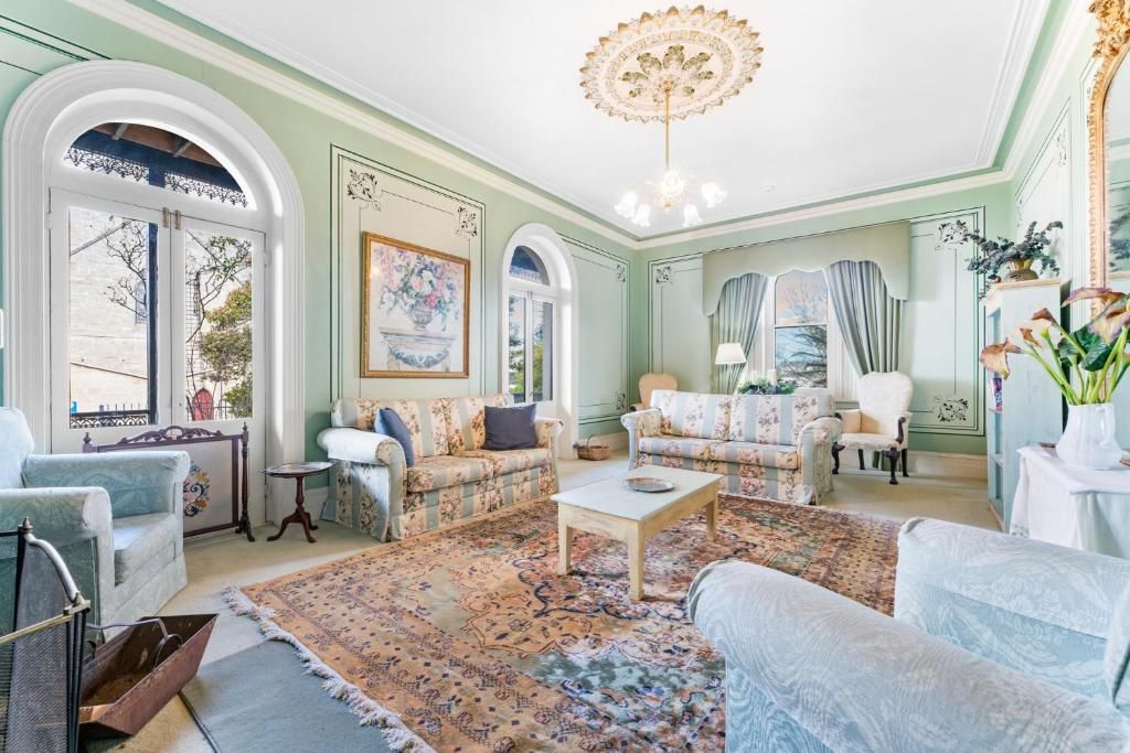 A room with a large window, a chandelier, and a patterned rug.