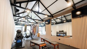 A gym with exercise equipment, benches, and a large window. - Little Drifter Surry Hills (Redfern)
