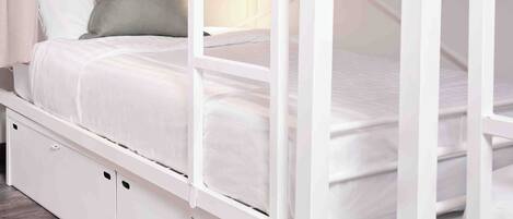 A bunk bed with a lower bunk and a mattress on the upper bunk.