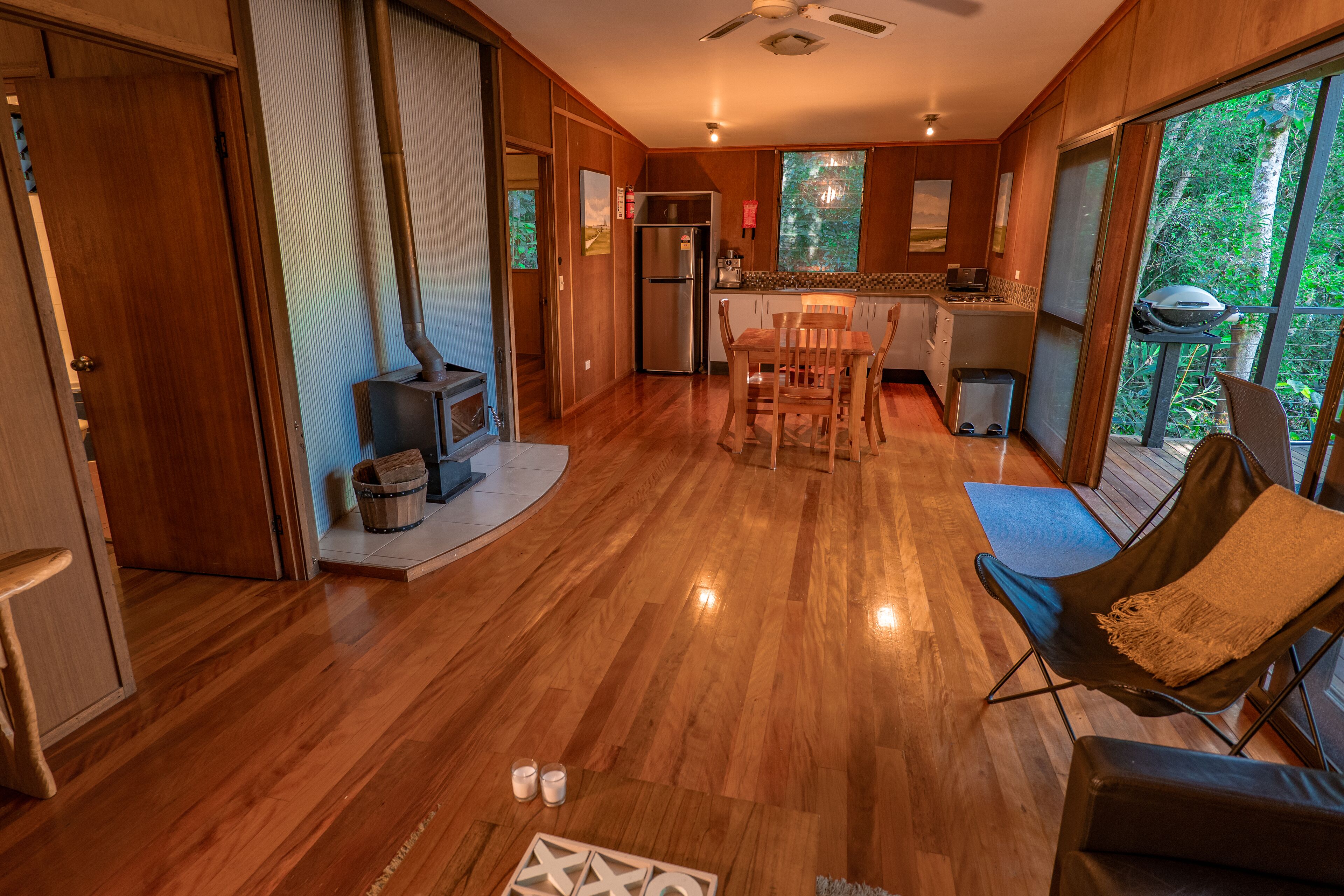 A spacious living area with a wooden floor, a dining table, and a comfortable seating area.