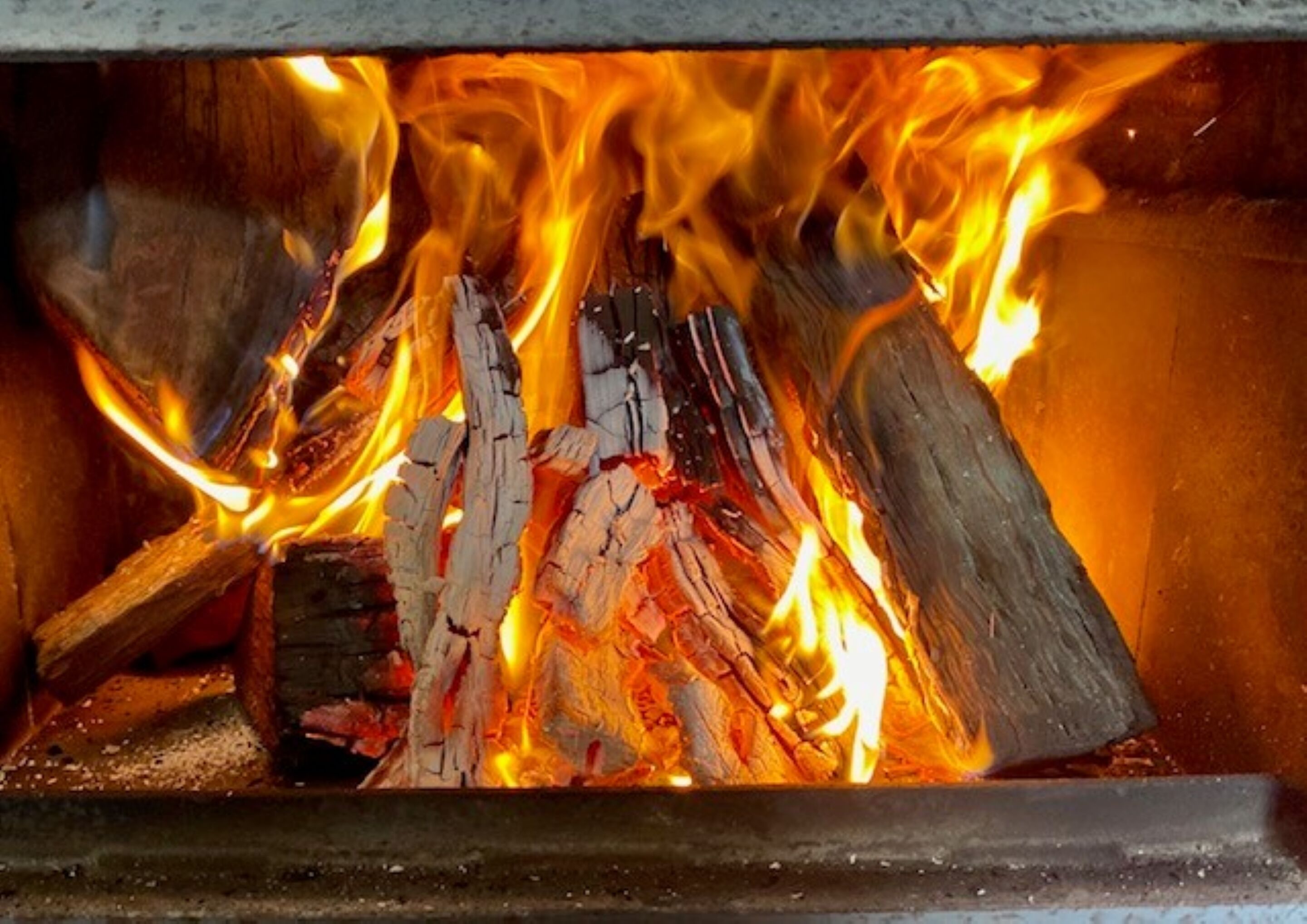 A fireplace with burning logs and flames.