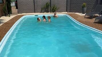 Alberca al aire libre, sombrillas en la alberca y camastros