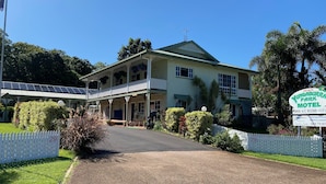 A two-story motel with a covered porch and a signboard.