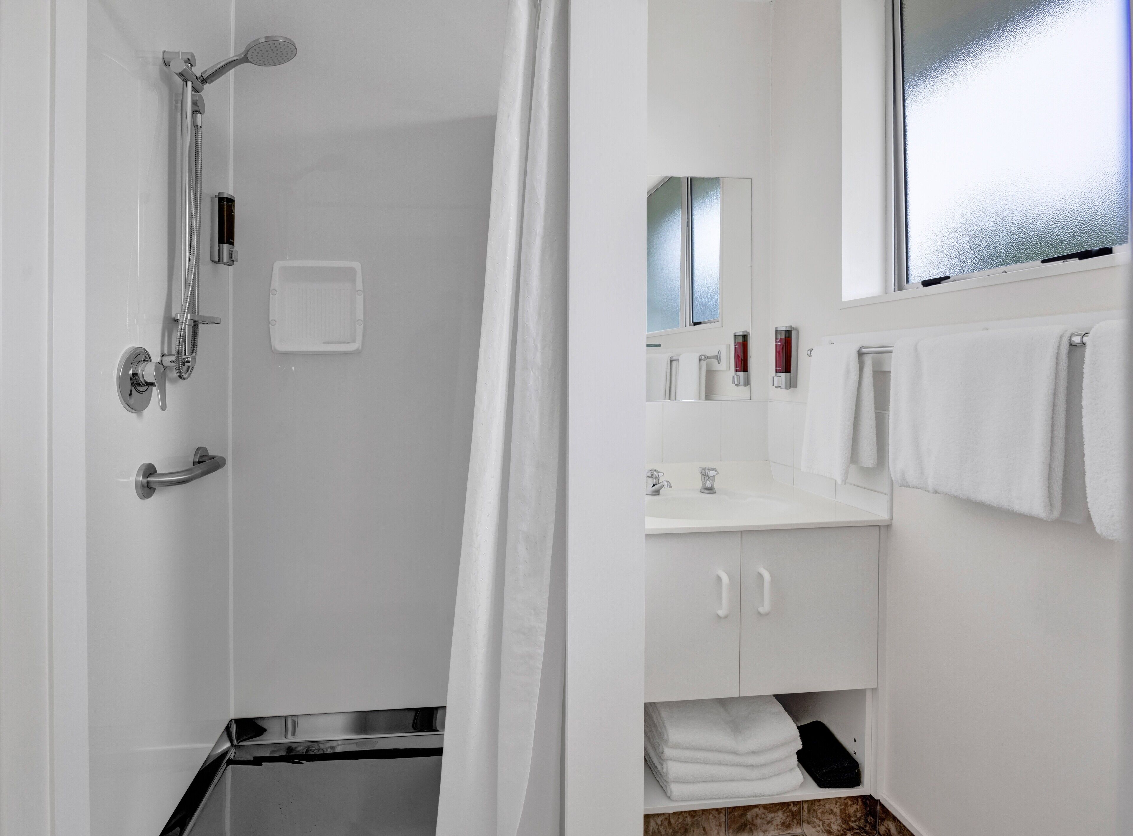 A modern bathroom with a shower, toilet, and sink.