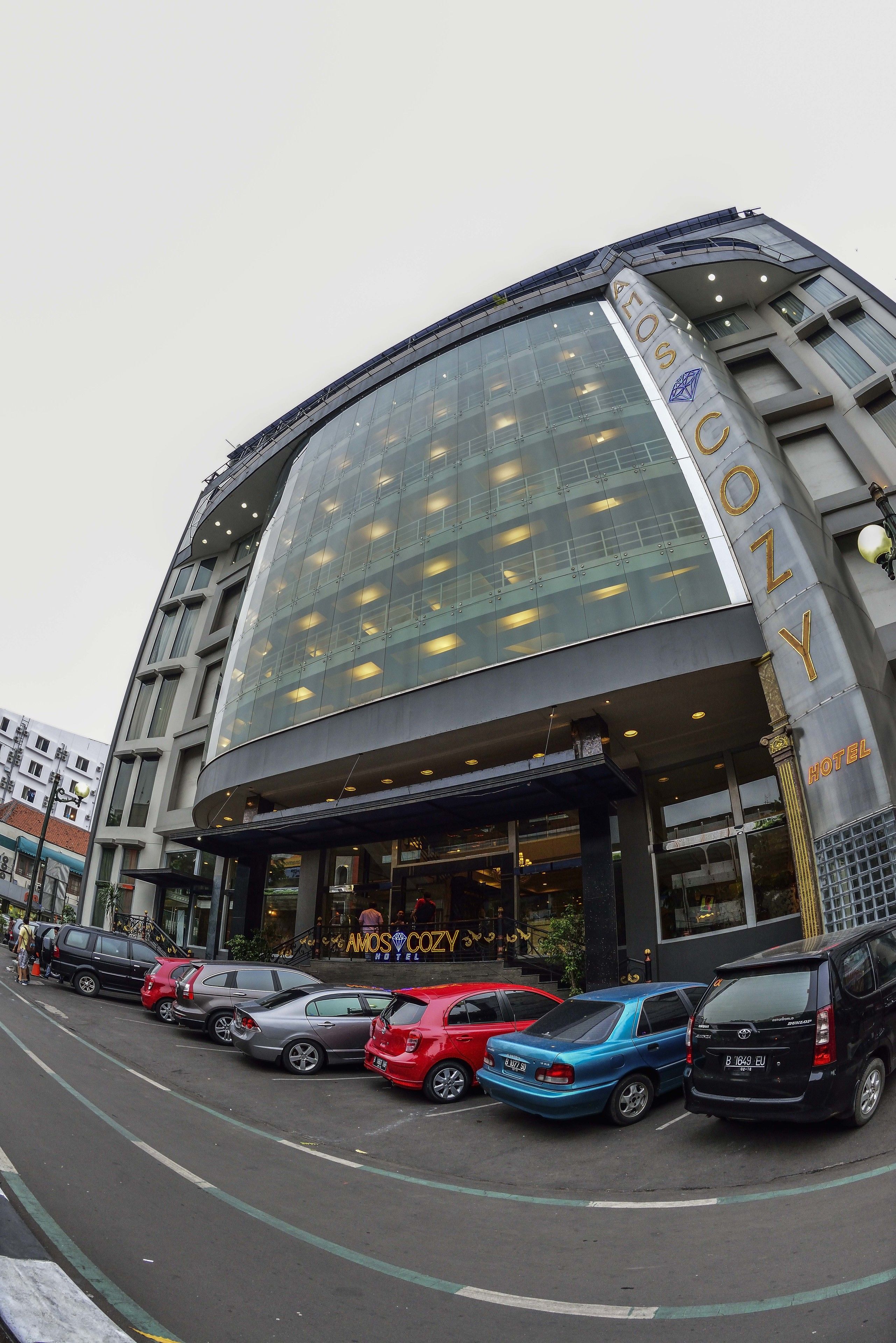 Un hotel con fachada de vidrio moderna y un cartel llamativo.